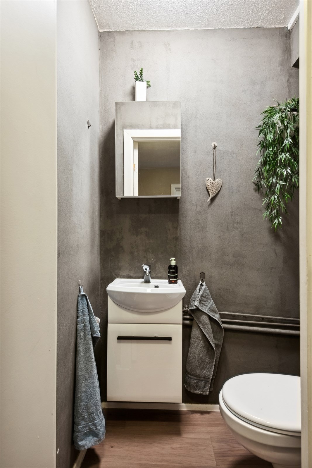 Leiligheten inneholder eget Wc/toalettrom med veggfestet toalett og innredning med nedfelt servant Galleribilde