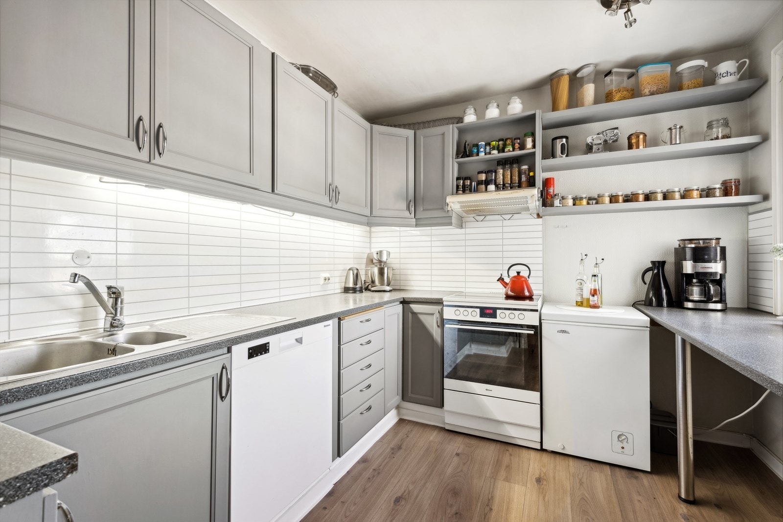 Boligens kjøkken har profilerte fronter og laminat benkeplate Galleribilde