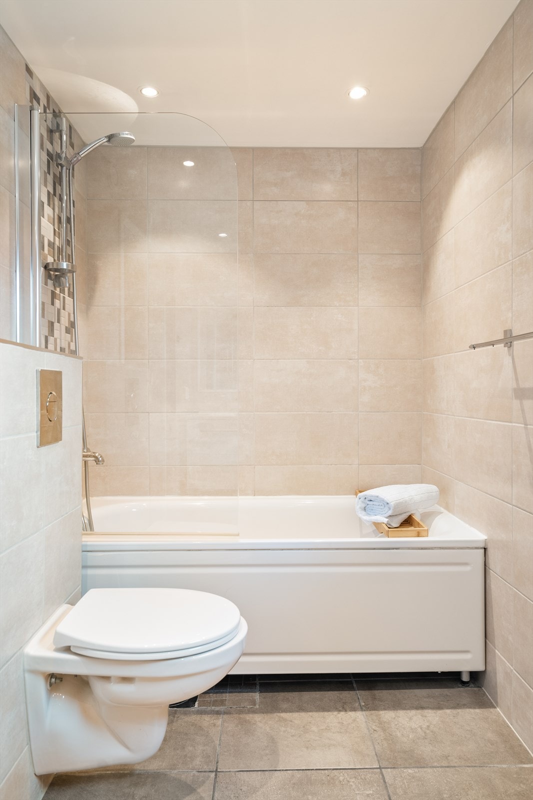 Innredning på badet fremstår med dusjplass i badekar med tilhørende garnityr, dobbel servant med
underskap, speil og veggmontert wc. Galleribilde