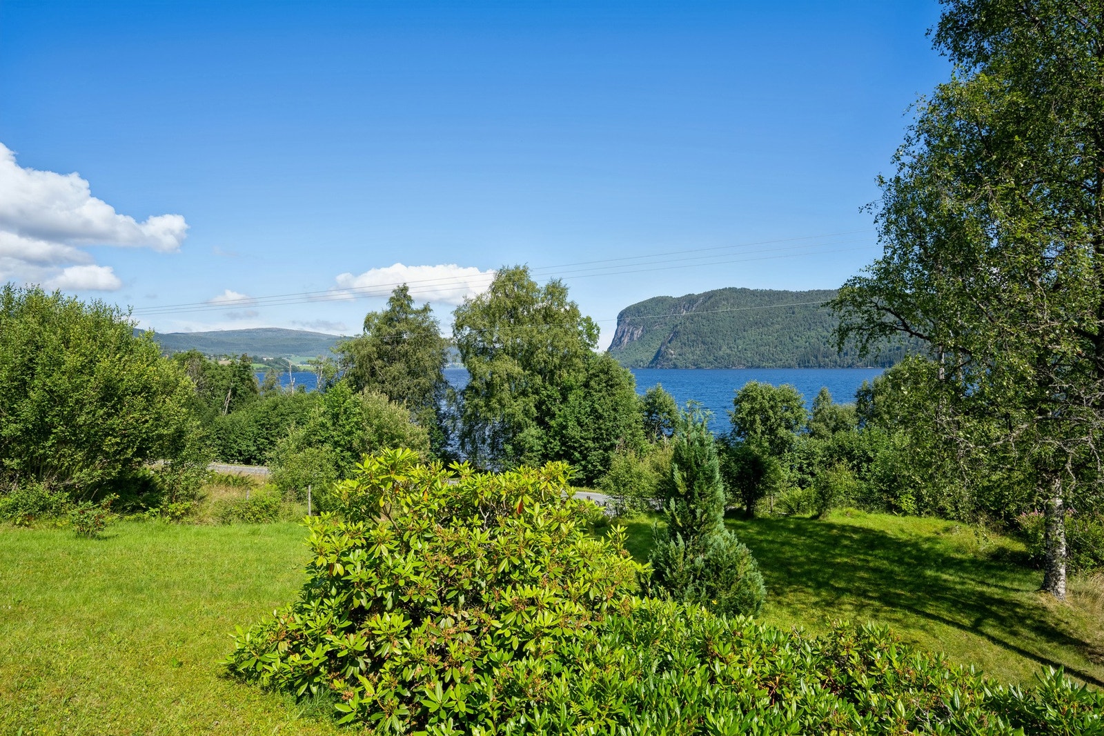 Tomten ligger litt opp i høyden slik at man kan nyte magisk utsikt mot vann, fjell og skogkledde åskammer. Galleribilde