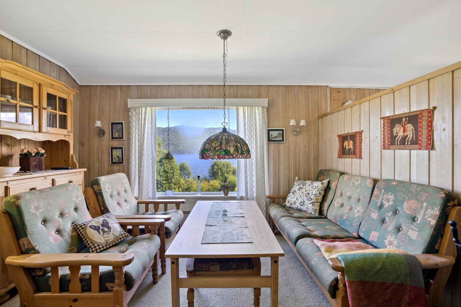 Stuen har vinduer på tre sider og det ene skaper en flott ramme mot den vidunderlige utsikten utenfor. Galleribilde