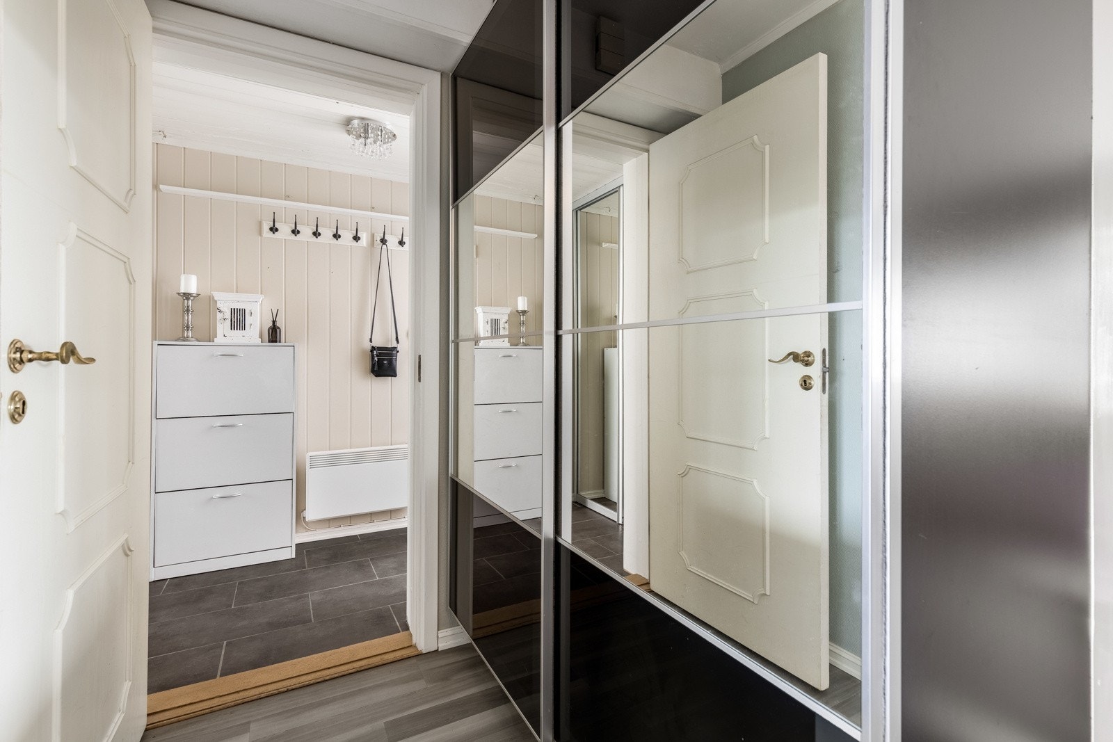 Entreen er hyggelig å komme hjem til med mørke gulvfliser, lyse vegger og flere knagger montert på veggen. Galleribilde