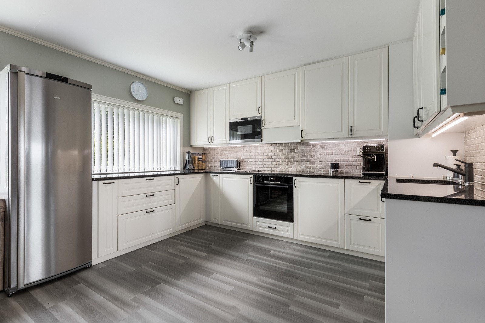 Over benken er det fliser og god belysning. Kjøkkenet har avsatt plass til kjøleskap og integrert i innredningen er det både platetopp, stekeovn, mikrobølgeovn og oppvaskmaskin. Galleribilde