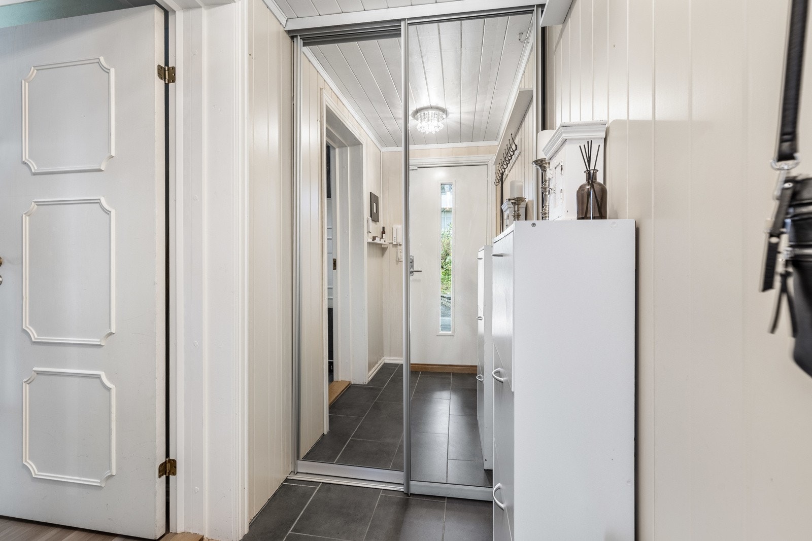 Entreen har også en skyvedørsgarderobe, og det er ytterligere en skyvedørsgarderobe montert rett innenfor døren til stue og kjøkken. Galleribilde