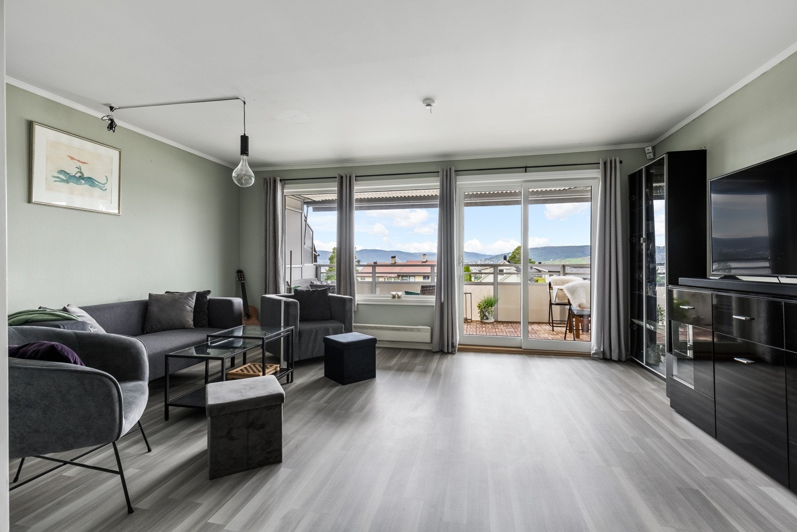 De generøse vindusflatene sørger for rikelig med naturlig dagslys som fyller rommet, noe som bidrar til en lys og luftig atmosfære gjennom hele dagen. Galleribilde