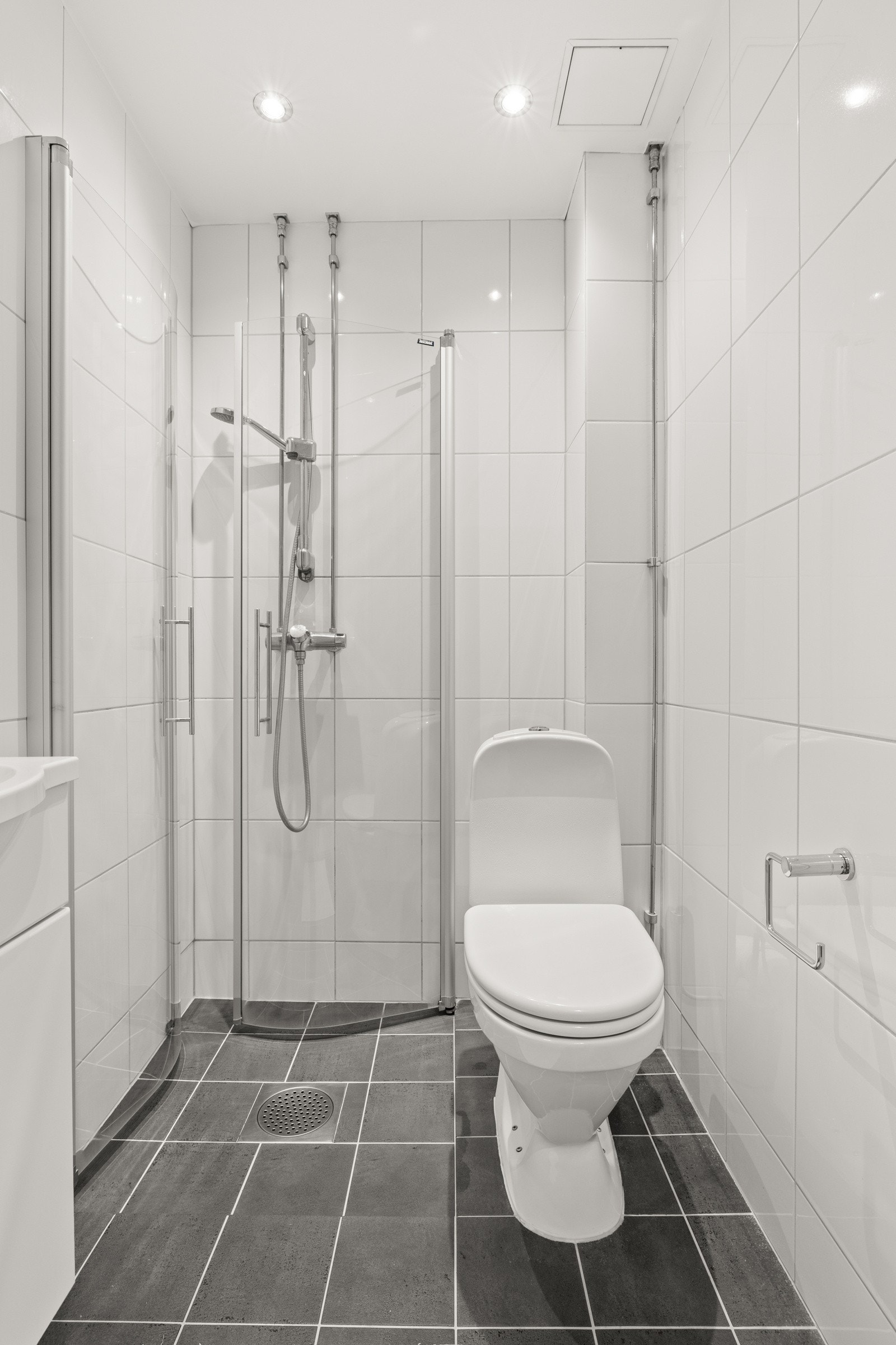 Badet er tatt i regi av borettslaget og er innredet med heldekkende servant med nedfelt underskap, speil, dusj med glassdører og toalett. Galleribilde