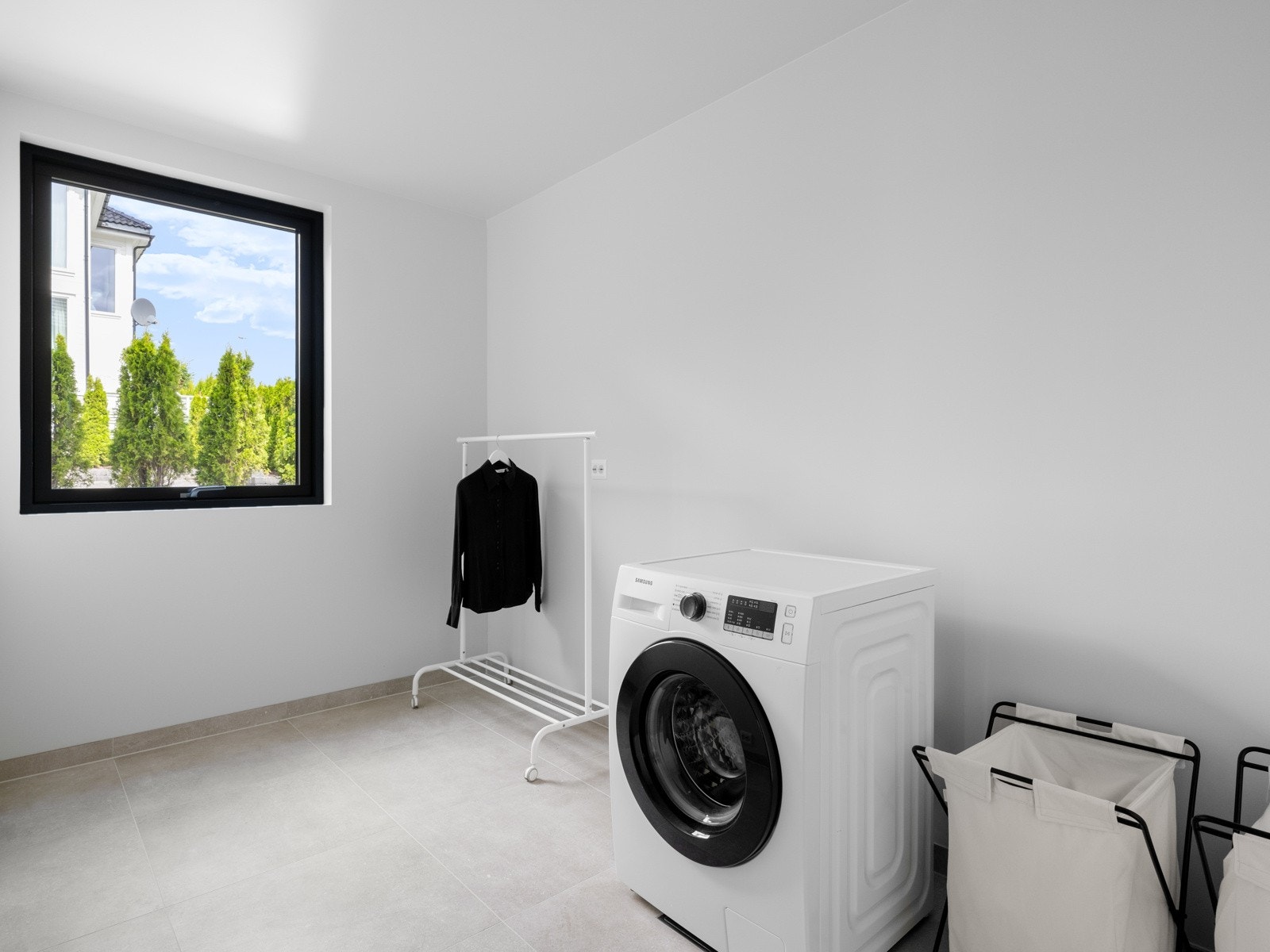 Vaskerommet har fliser på gulvet med varmekabler og opplegg til vaskemaskin. Galleribilde