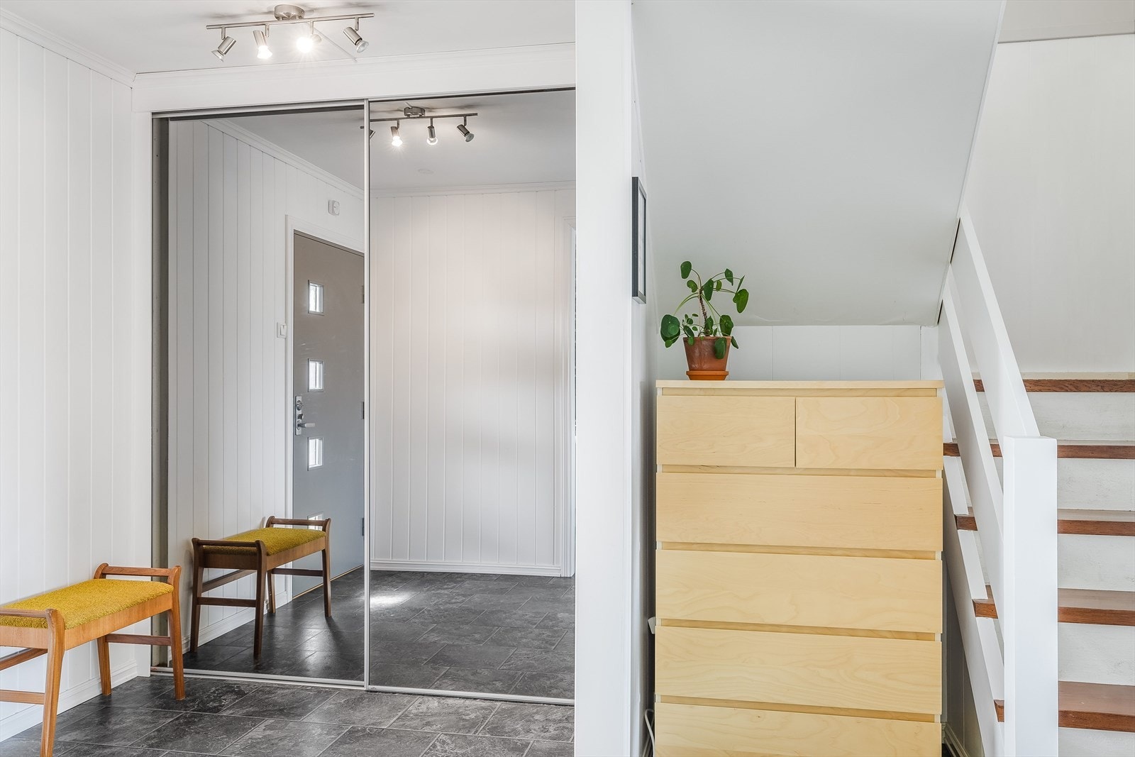I entréen har du god oppbevaringsplass i stor plassbygget skyvedørsgarderobe, samt ytterligere plass til kommode. Bak kommoden er det en dør til et lite kott under trappa. Galleribilde