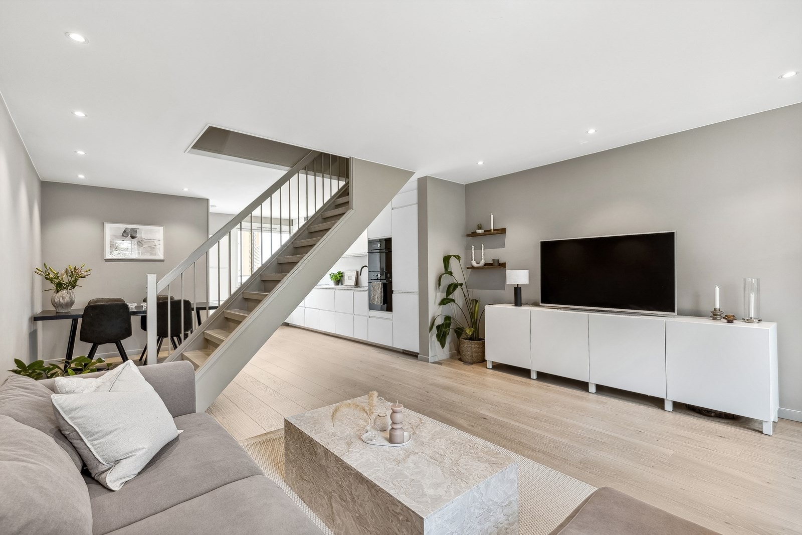 Hele 1. etasje har et moderne og stilrent preg, med lyse overflater. Taket er senket med integrerte downlights. Galleribilde