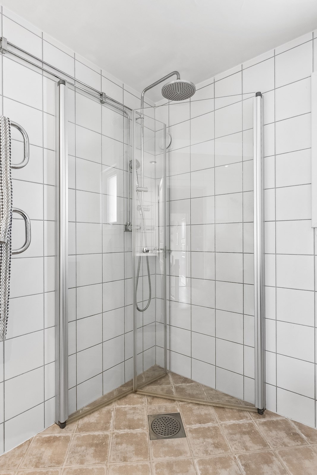 Rommet har også et stort dusjhjørne med regnfallsdusj og svingbare glassvegger. Det er også montert håndkletørker. Galleribilde