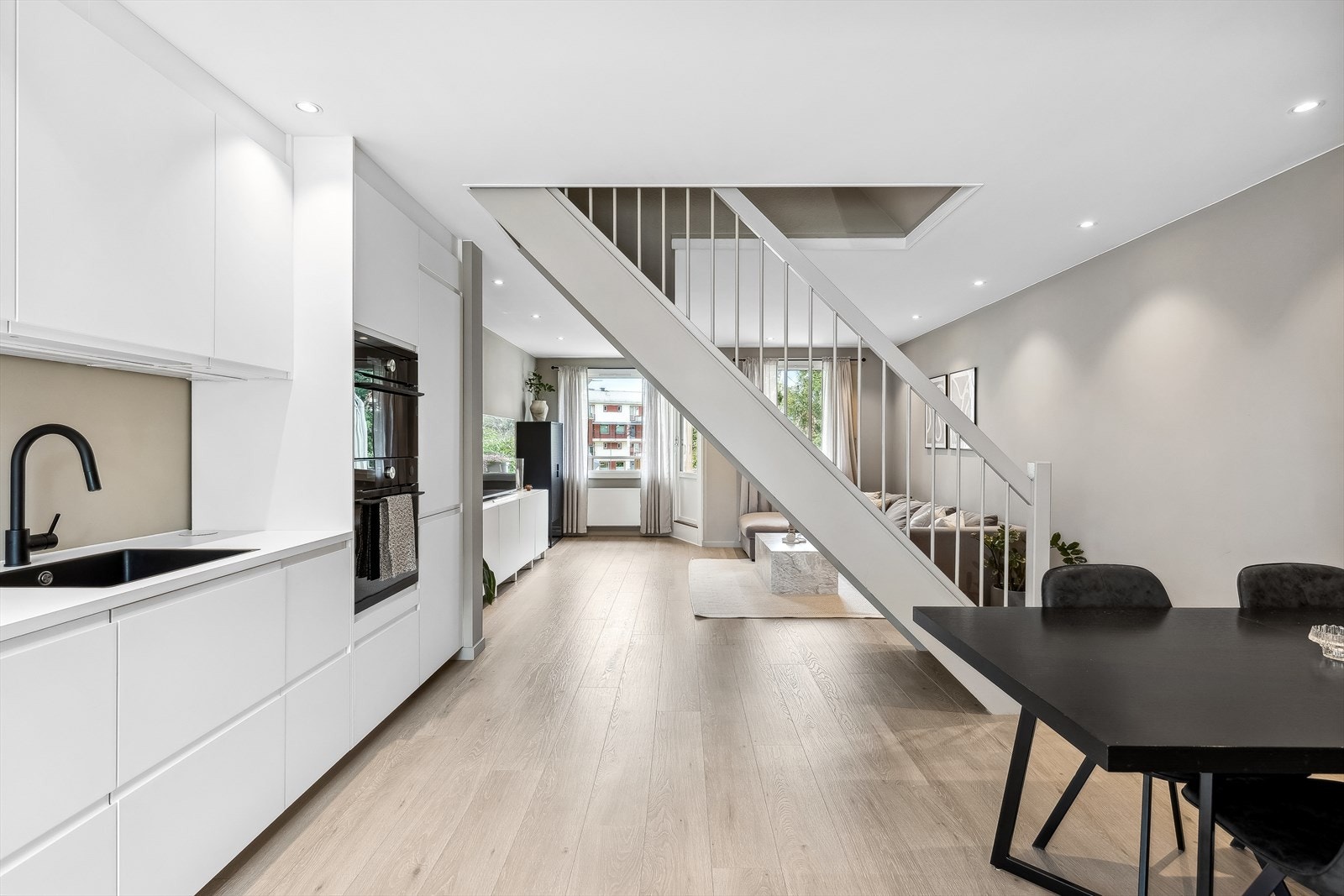 Det er åpnet gjennom hele 1. etasje, men trappen gir samtidig et fint skille mellom kjøkkenet og stuen. Galleribilde