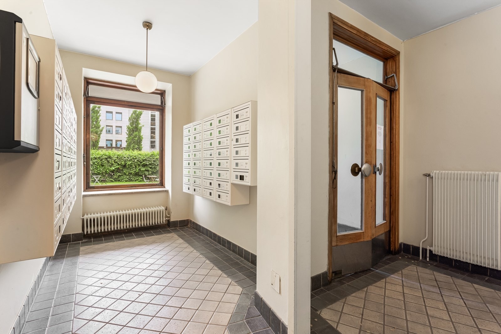 Pent og velholdt inngangsparti med postkasser som åpnes med brikke Galleribilde