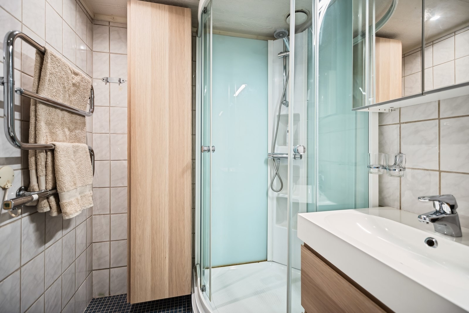 Flissatt bad med moderne innrending, dusjkabinett og frittstående toalett. Galleribilde