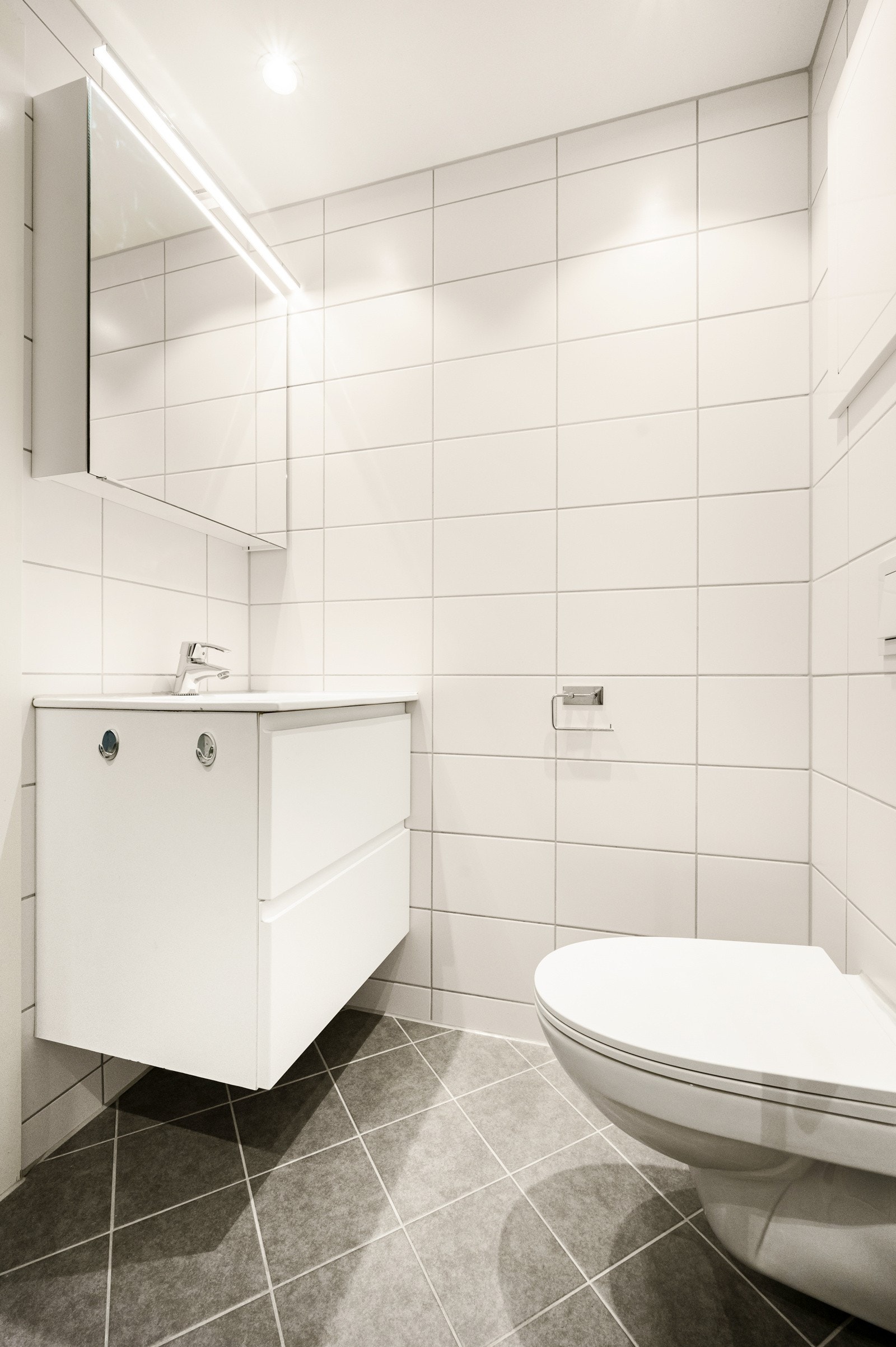 Flott og lyst vegghengt servantskap og speil med belysning. Galleribilde