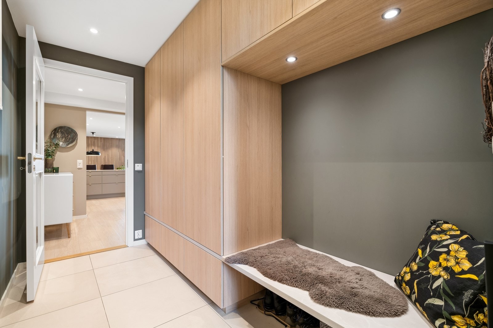 Her ønskes du velkommen inn i en hyggelig flislagt entrè med gulvvarme - Entreen er utstyrt med plassbygget garderobeløsning som gir rikelig plass til oppbevaring Galleribilde