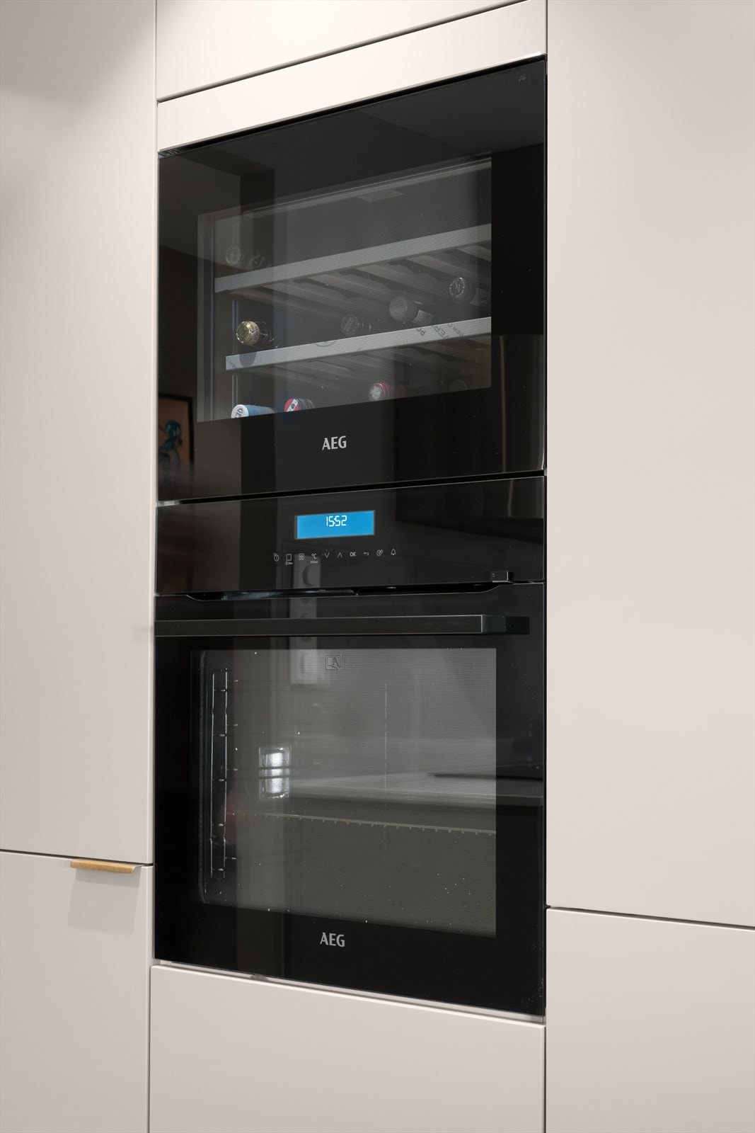 De integrerte hvitevarene medfølger og består av komfyr, ekstra bred koketopp, oppvaskmaskin, kjøleskap, fryseskap og vinskap Galleribilde