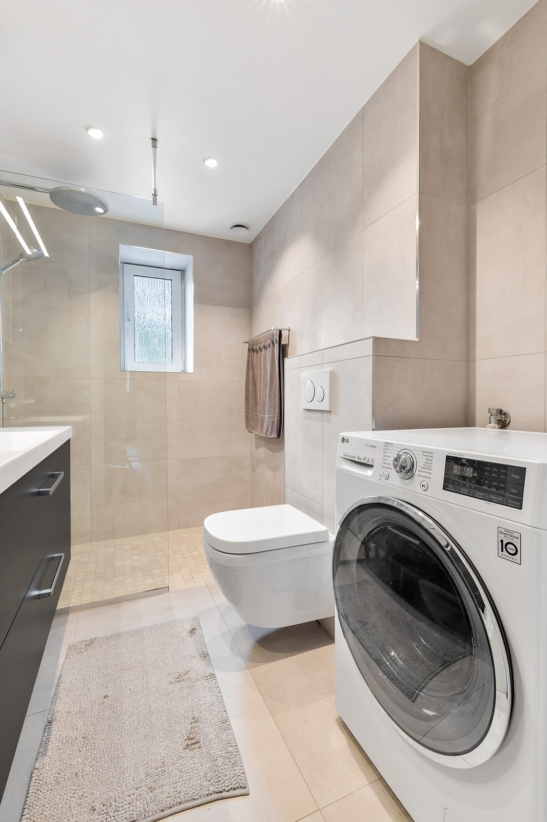 Lyst og delikat bad med opplegg for vaskemaskin. Galleribilde