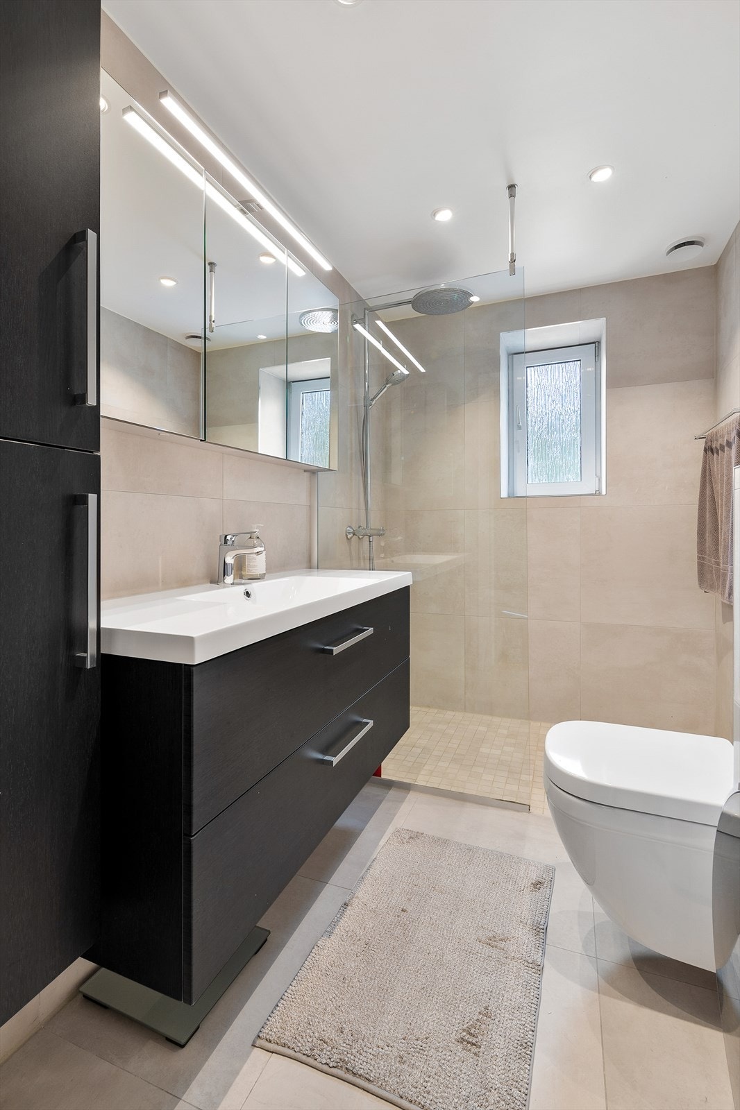 Lekkert bad fra 2020 med flislagte overflater på gulv og vegger. Det er elektriske varmekabler i gulvet. Galleribilde