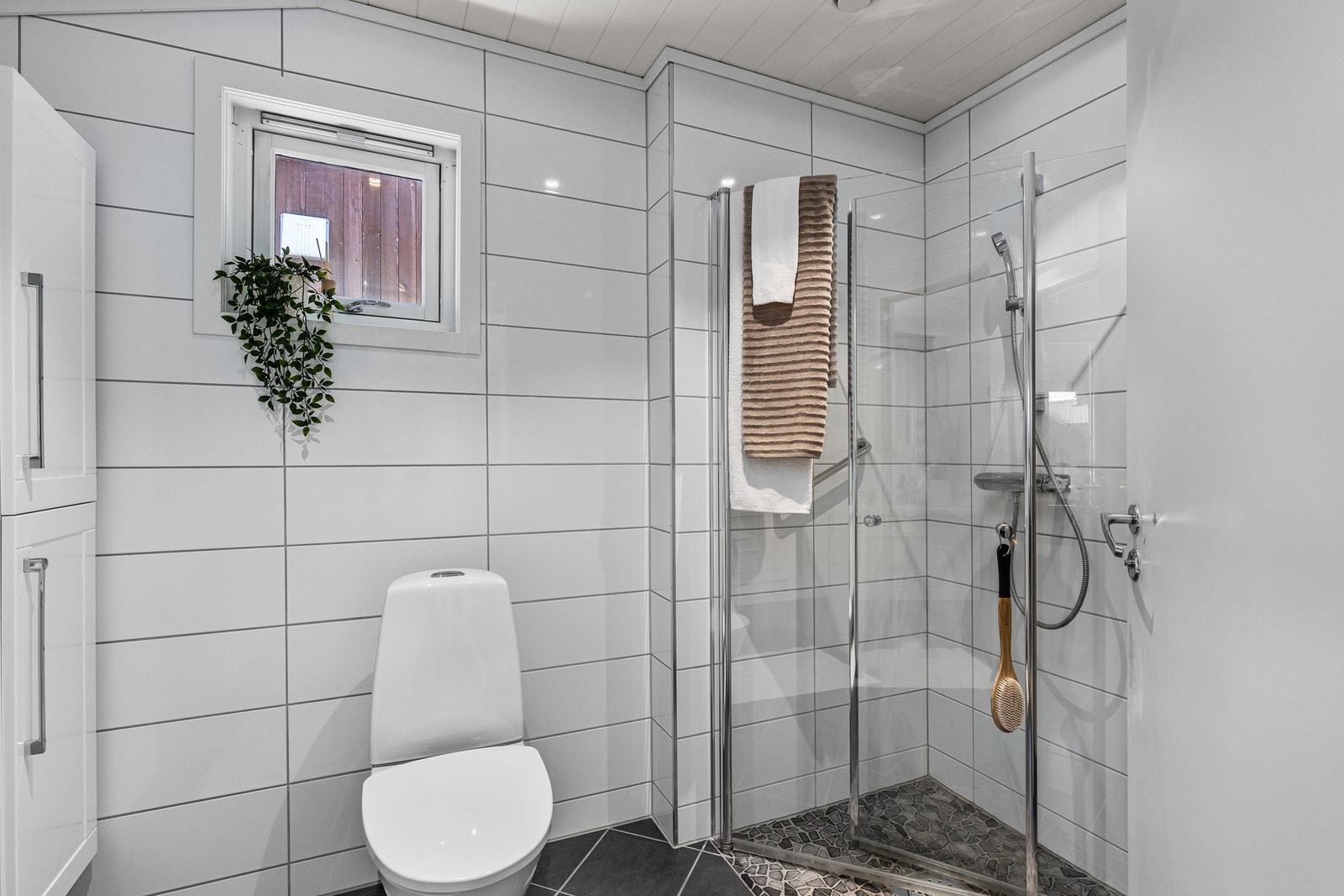 Badet er på 4,8 kvm og oppleves som lyst og moderne. Galleribilde