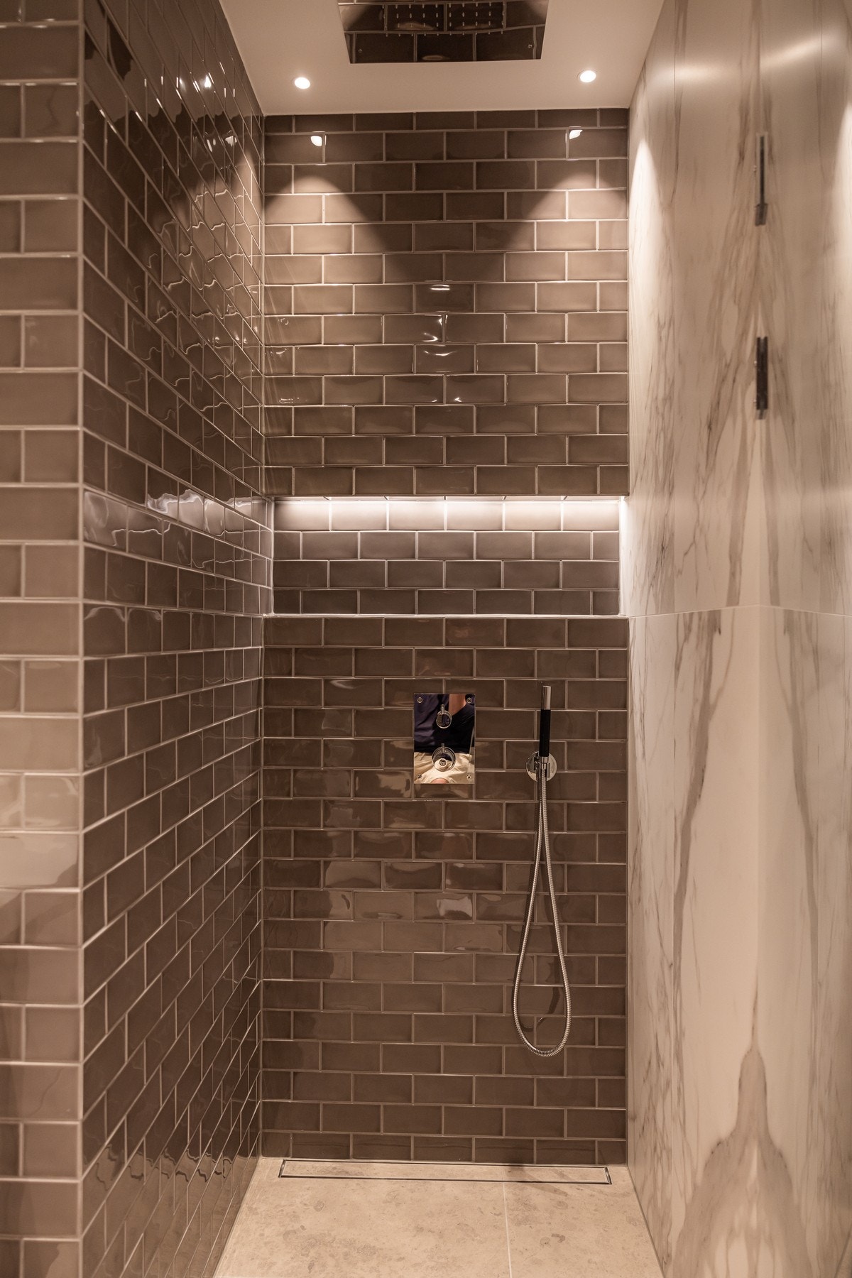 Dette badet er utstyrt med vegghengt toalett, dusjnisje med regnfallsdusj fra
Tapwell og en stilfull servant, og er pent innredet med marmorerte fliser og integrert speil. Galleribilde