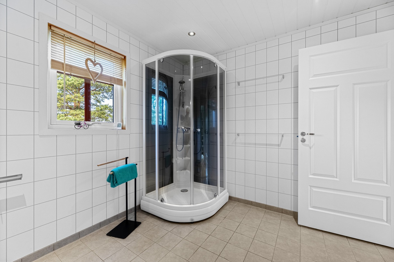Badet er innredet med toalett, bidet, dusjkabinett, og servant med skap, speil og lys Galleribilde