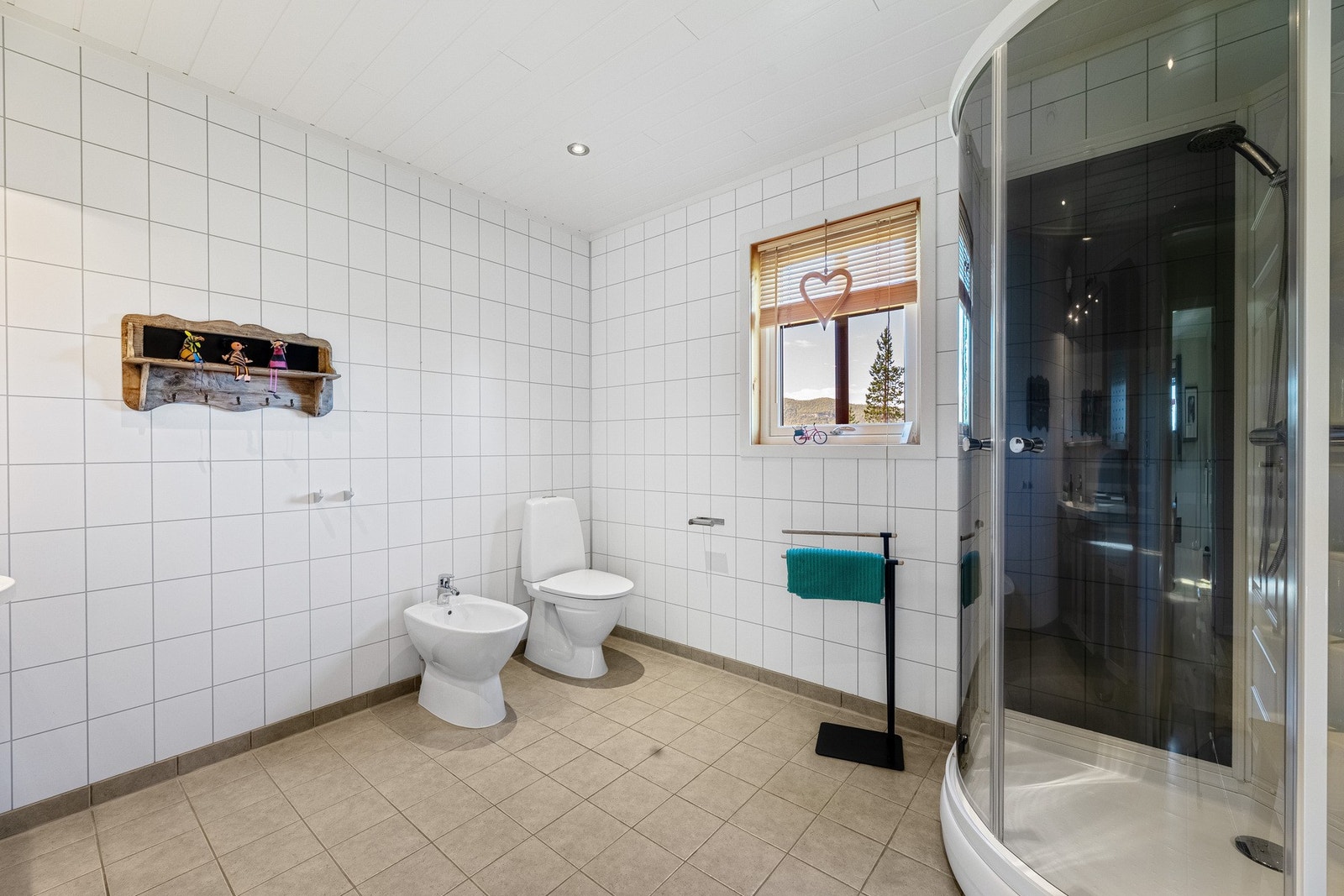 Badet har våtromsplater på vegger og flislagt gulv Galleribilde