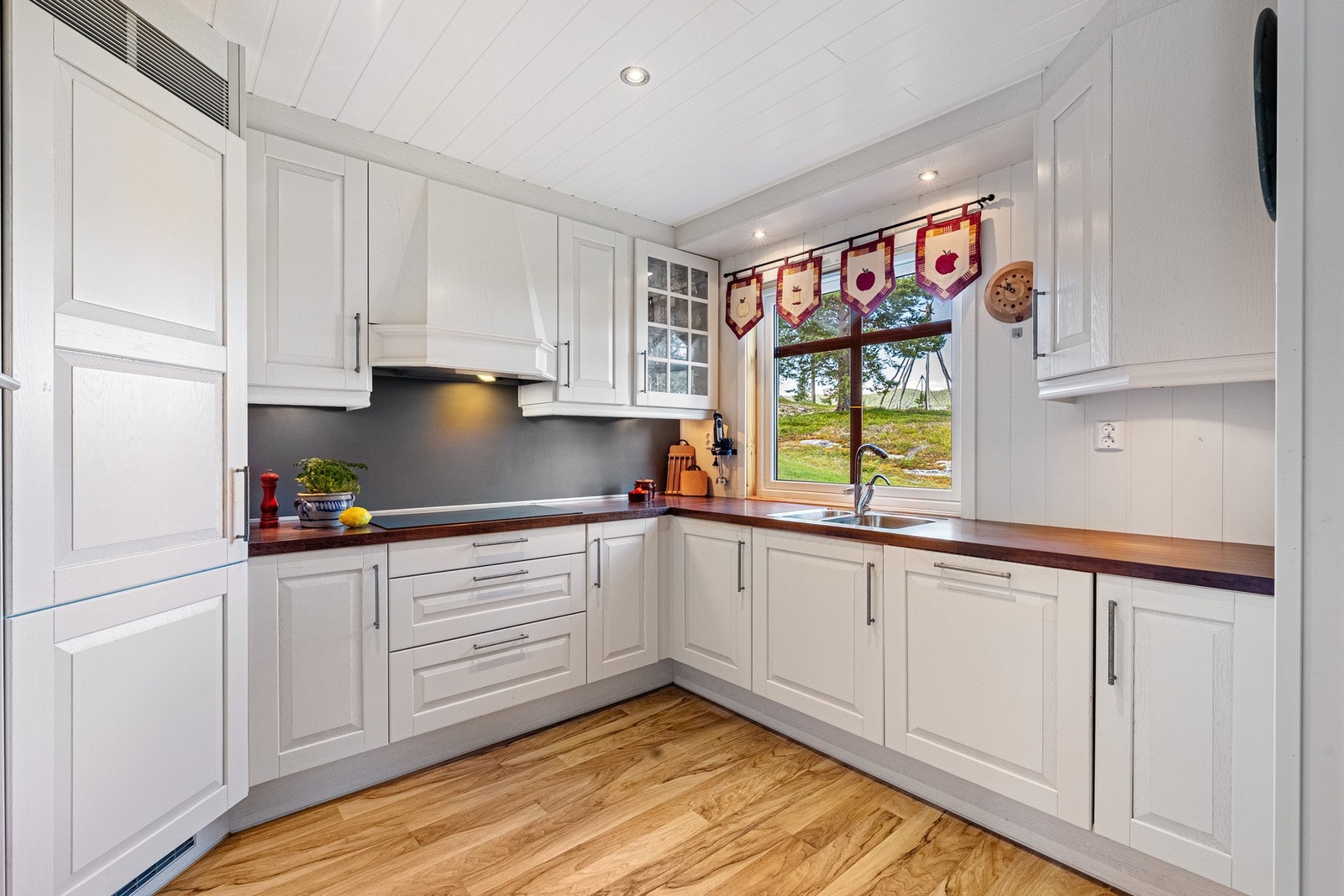 Lys kjøkkeninnredning med hvite, profilerte fronter og benkeplate av laminat Galleribilde