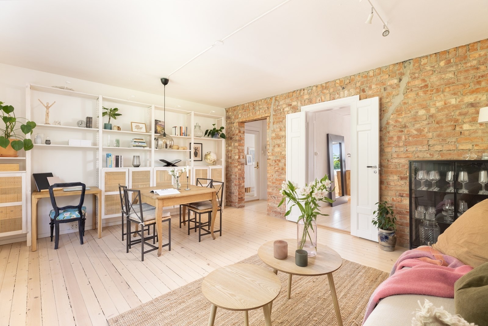 I stuen er det flotte, originale detaljer med tregulv, teglsteinsvegg og fløydør Galleribilde