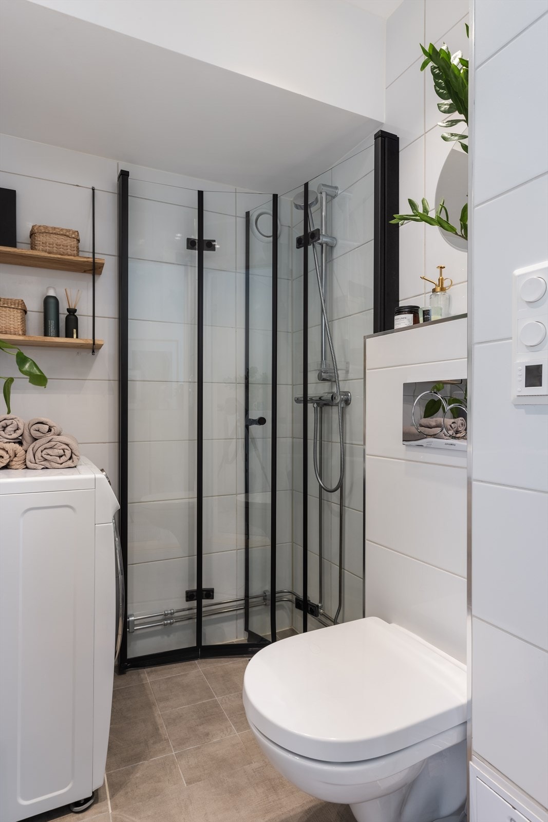 Rommet inneholder heldekkende servant på underskap, speil og belysning, vegghengt toalett og dusjhjørne med innfellbare dører Galleribilde