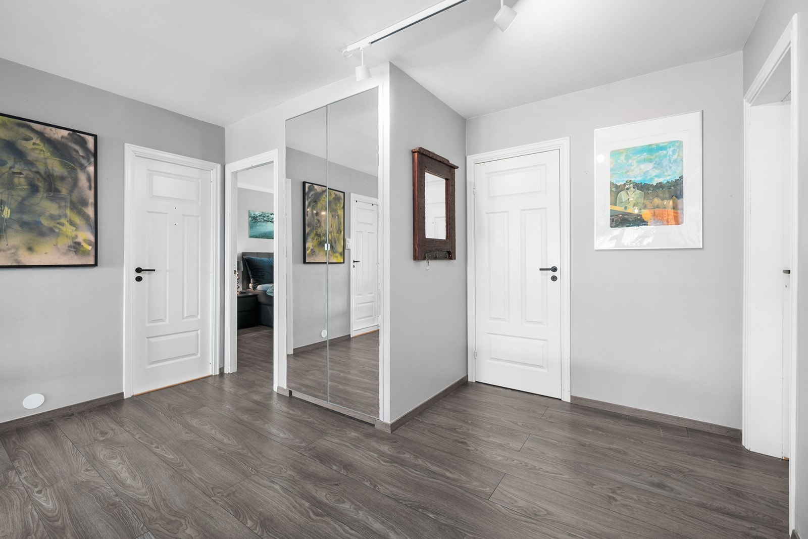 Vel innenfor døra blir du møtt av en åpen romløsning. Entrévegger og kjøkkenvegger er fjernet. I entreen står et garderobeskap med speildører. Galleribilde