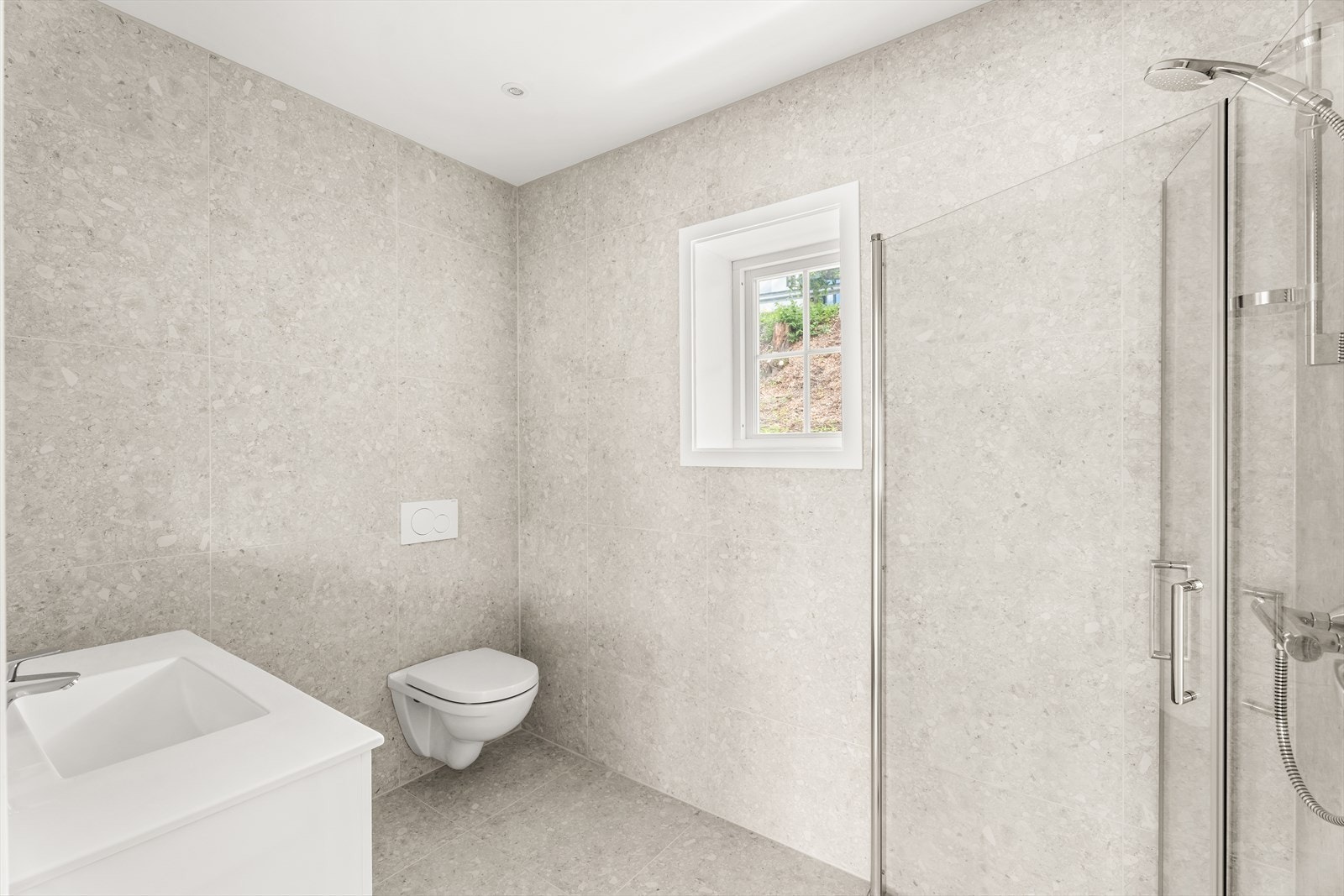 Moderne innredet bad med deliakte fliser, badet er utstyrt med servantinnredning og dusjhjørne med glassdører, samt varmekabler i gulvet! Galleribilde