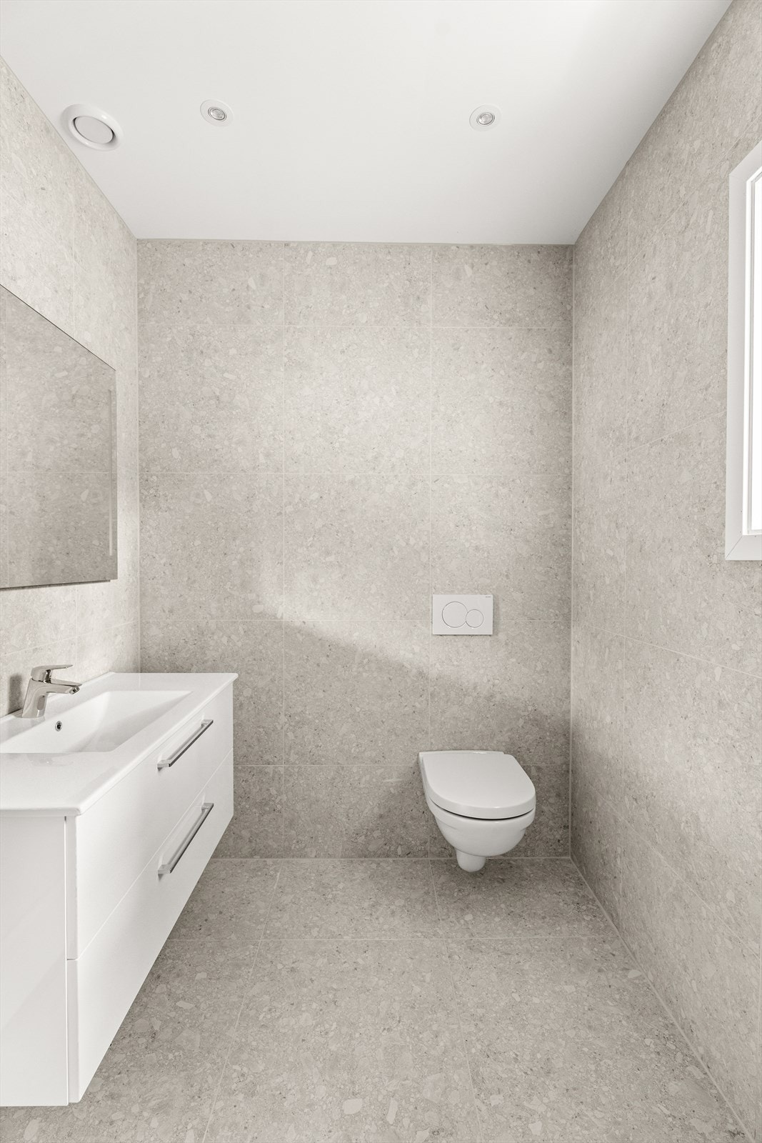 Servant nedfelt i skapinnredning, vegghengt toalett og spotter i lysmalt himling. Galleribilde