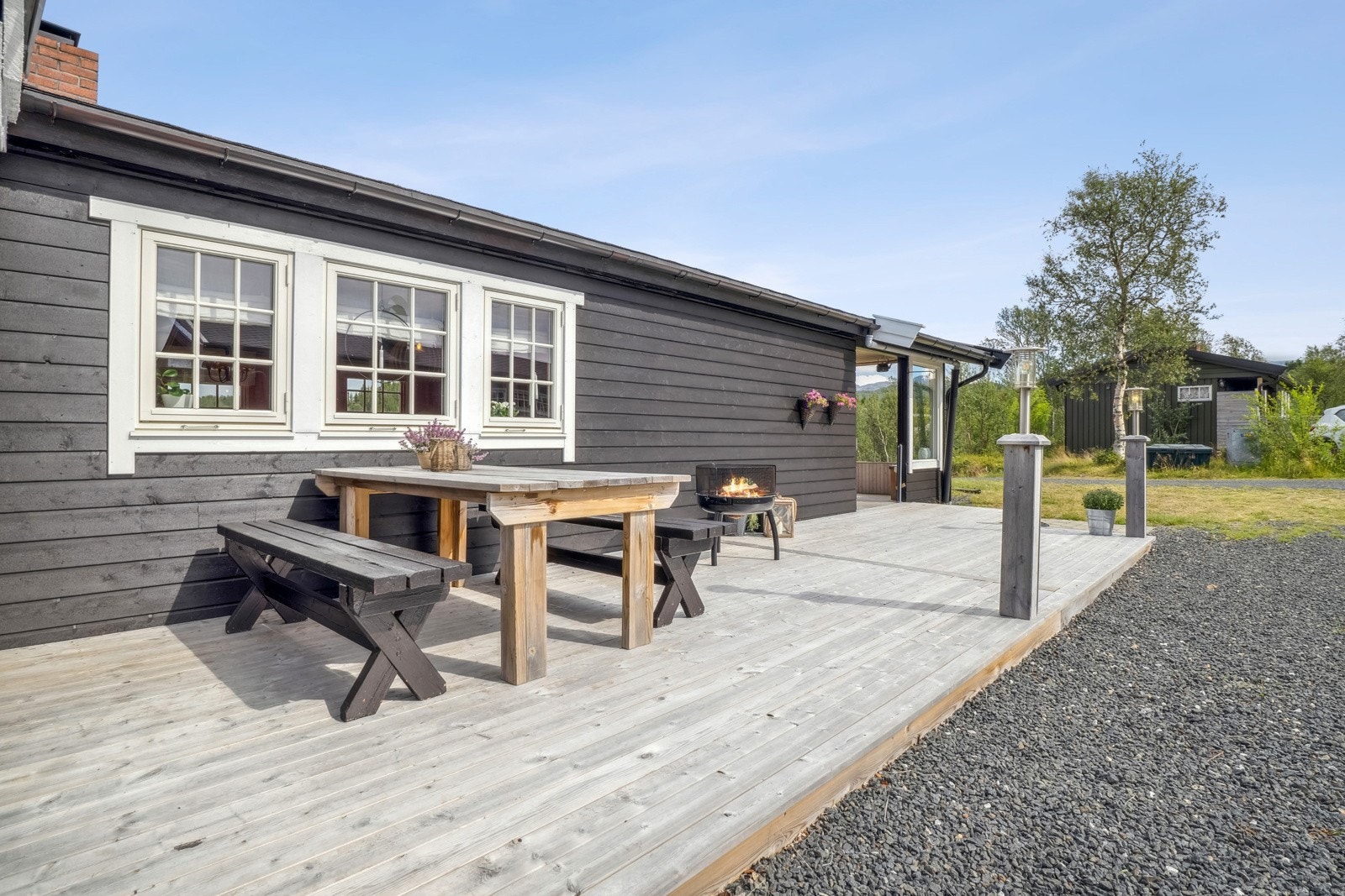 Stor og fin terrasse som strekker seg rundt hytta, med sol på ettermiddag og kveld Galleribilde