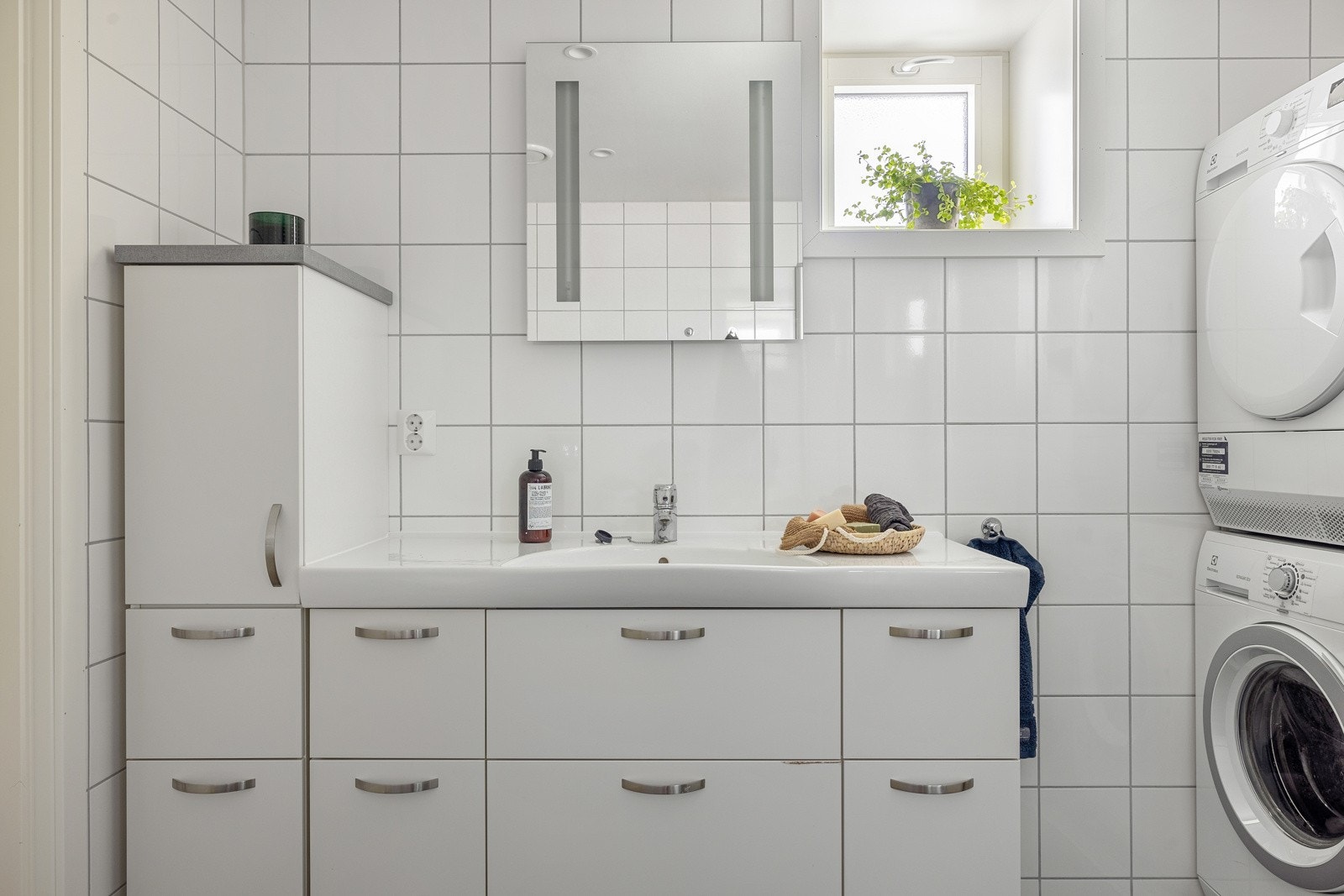 Badet er har en tidløs innredning med dusj med glassvegger, vegghengt toalett og baderomsinnredning. Galleribilde