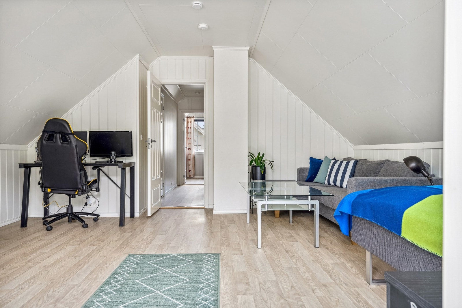 Stue. Her innredet med seng, sofa og spill/kontorpult. Galleribilde