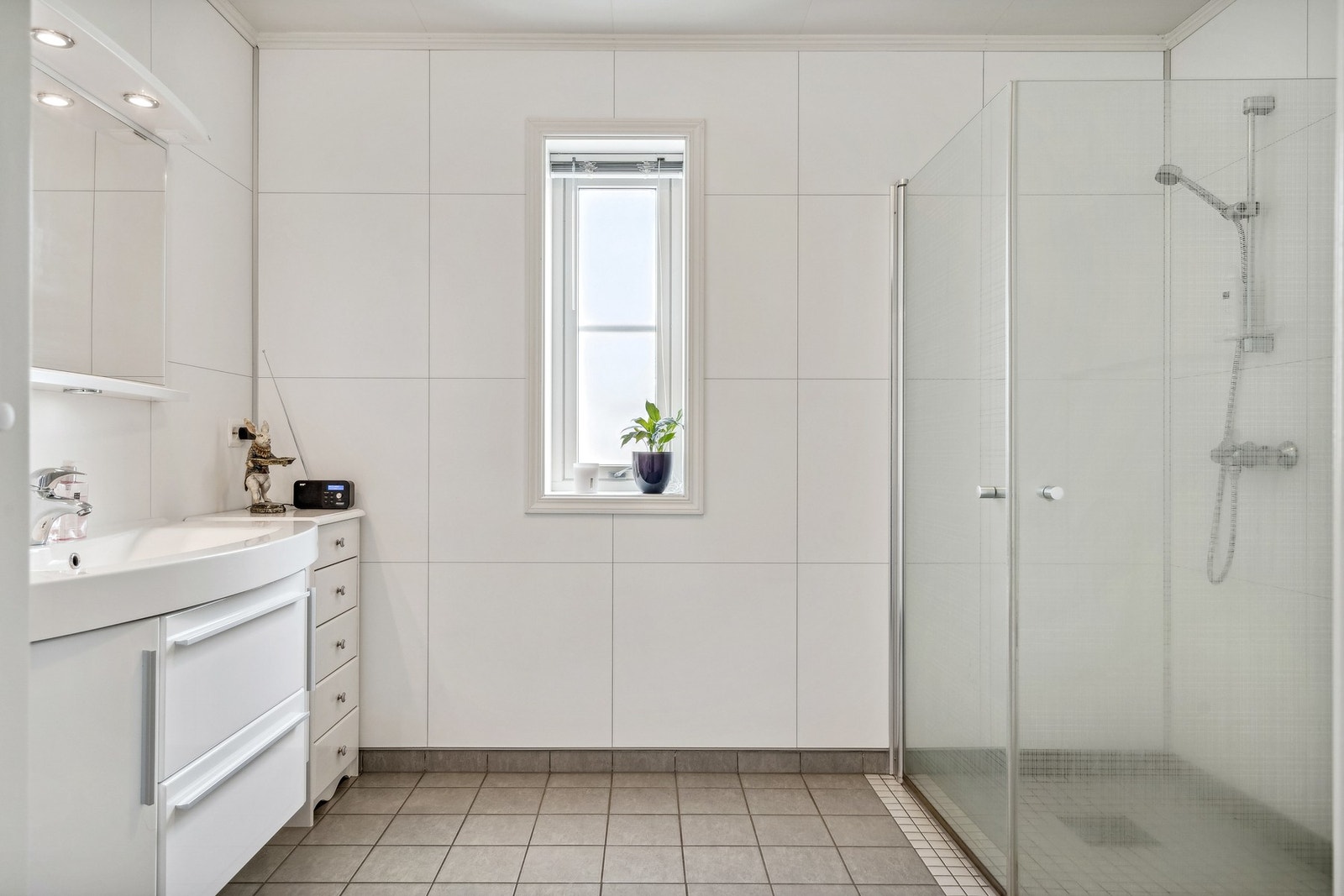 Bad med varmekabler, veggmontert toalett, nedfelt servant og dusjhjørne. Galleribilde