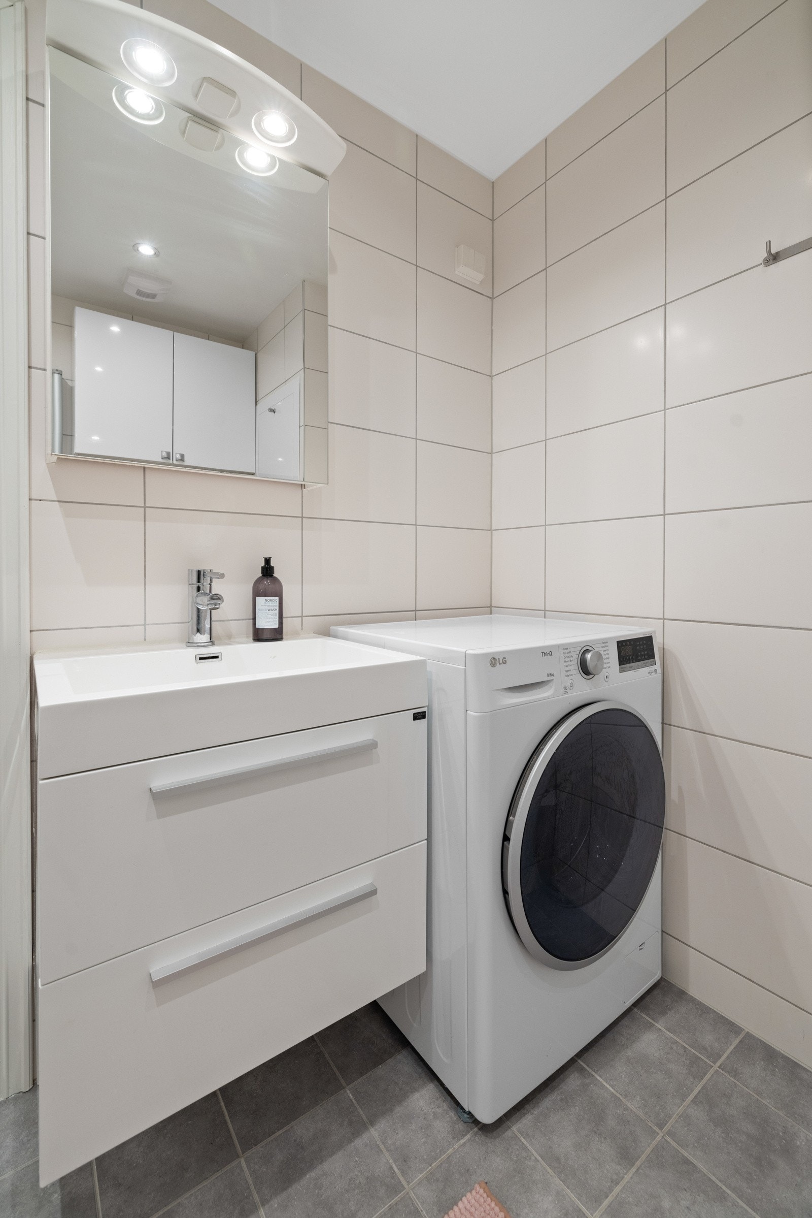 Baderomsinnredning med servantskap med skuffer og overliggende servant i porselen med ett-greps blandebatteri. Galleribilde