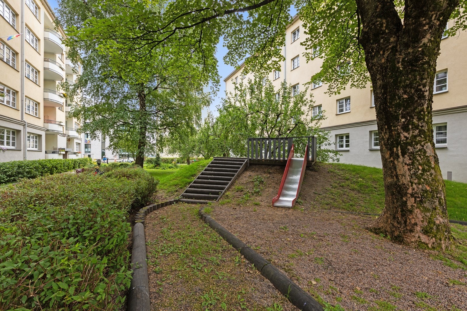 Bakgården byr på lekeplass, frukttrær, diverse utemøbllement og griller til bruk for andelseierne. Galleribilde