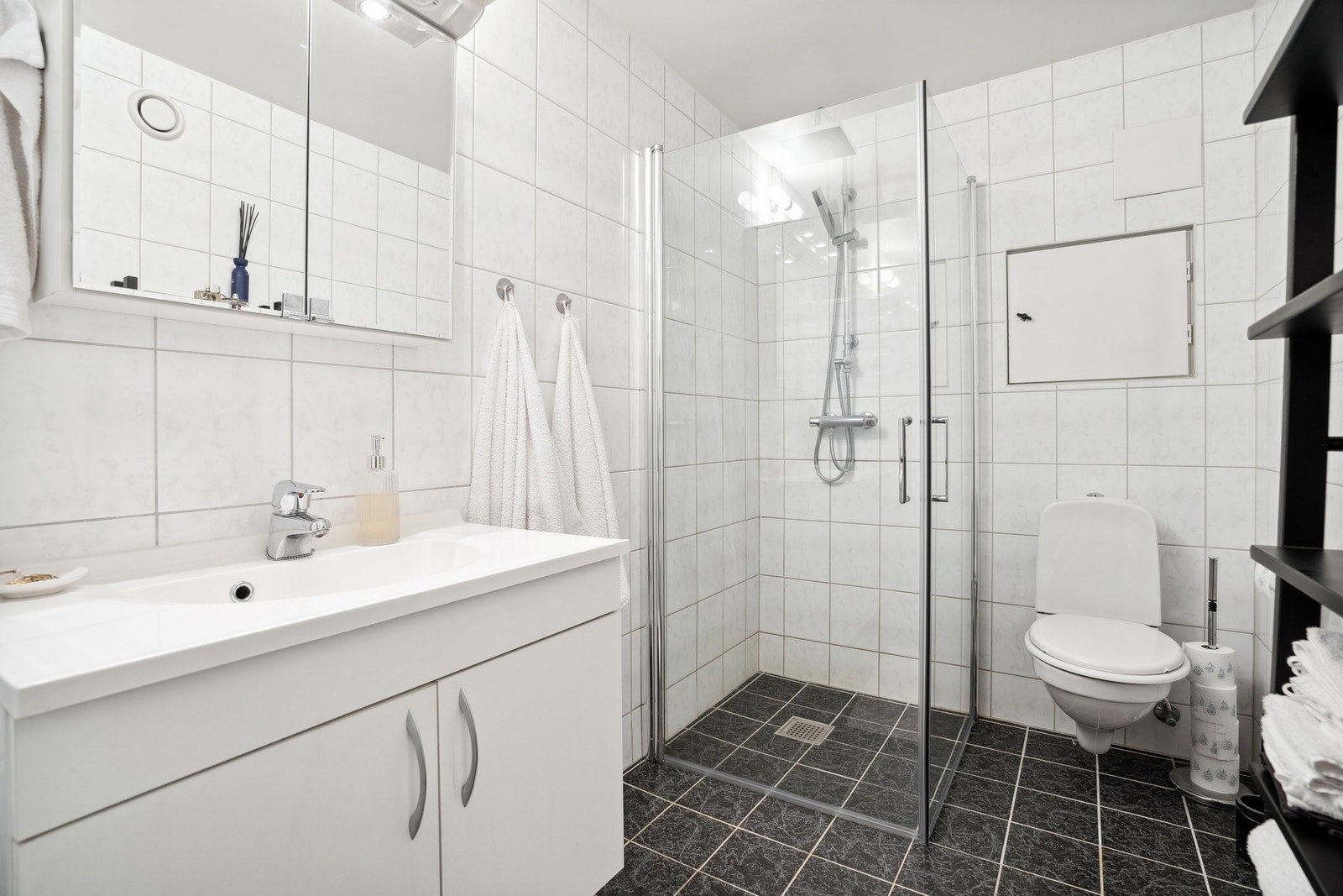 Veggmontert toalett og dusjhjørne med glassdører. Galleribilde