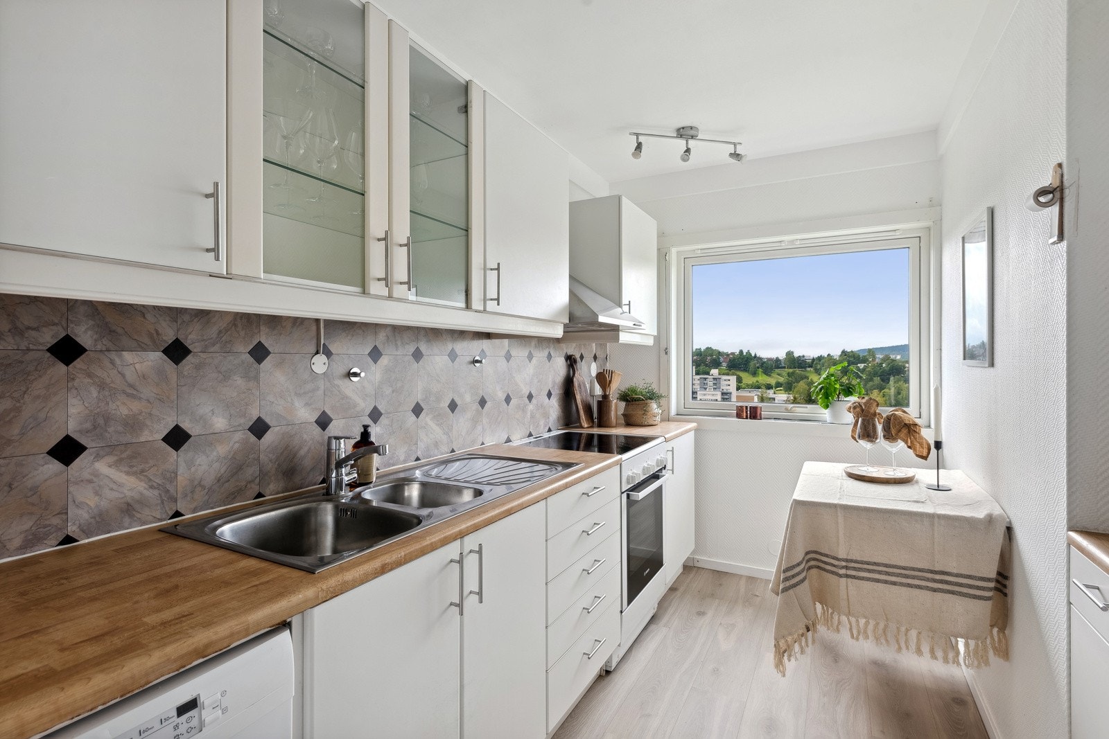 Kjøkkeninnredning med slette folierte fronter, 2 stk. fronter med glass og laminat benkeplate Galleribilde