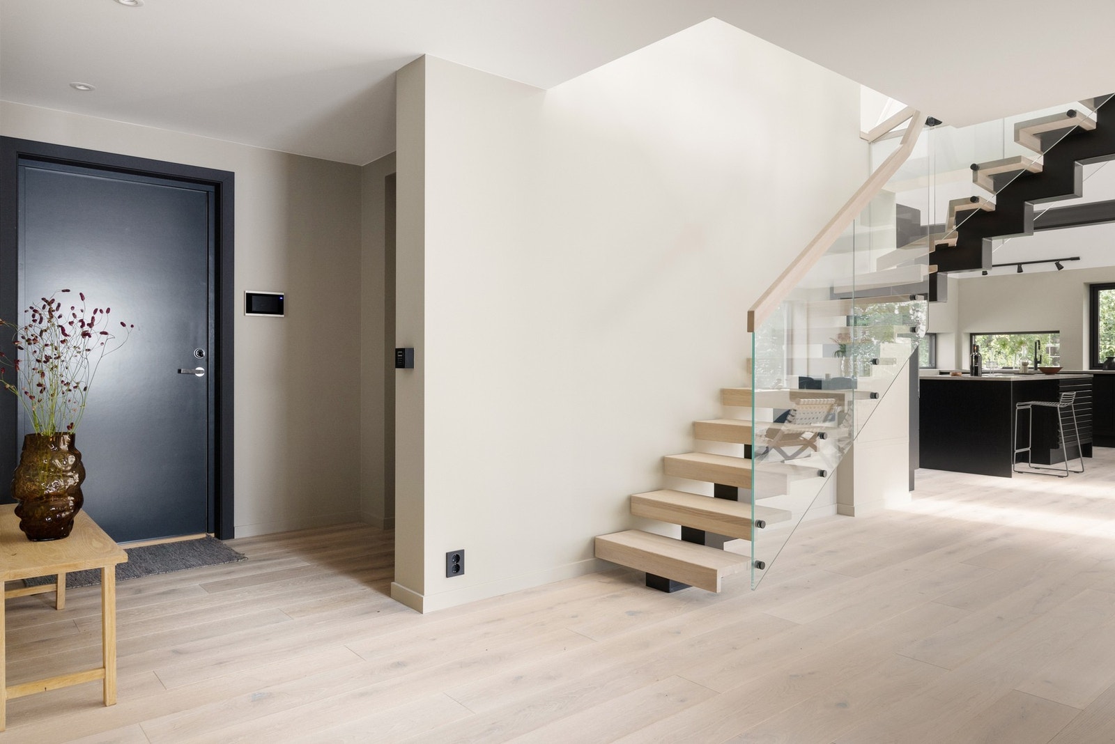 Leiligheten har en romslig entré og mellomgang som gir et flott førsteinntrykk. Den vakre glasstrappen som forbinder de to etasjeplanene er et designmessig høydepunkt, og tilfører rommet et ekstra sofistikert uttrykk. Galleribilde