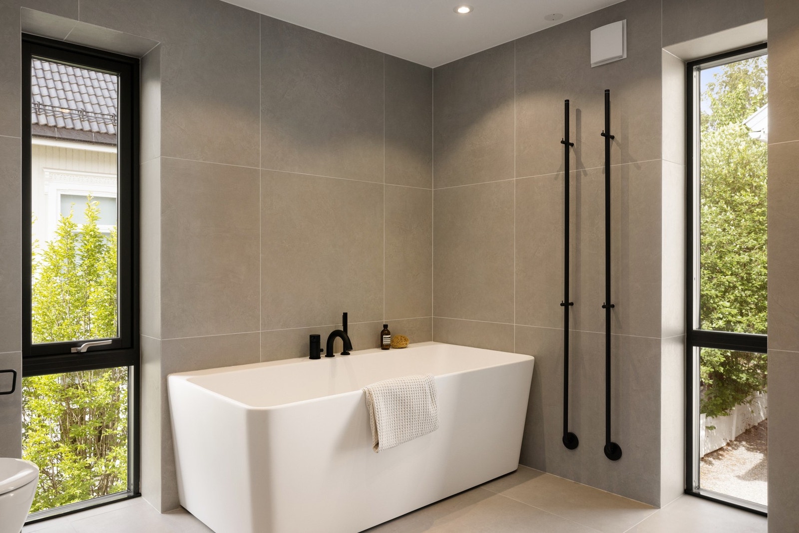 Badet er nydelig innredet med dobbel servant, bredt speil med belysning, regnfallsdusj, badekar, håndkletørker og toalett. Galleribilde