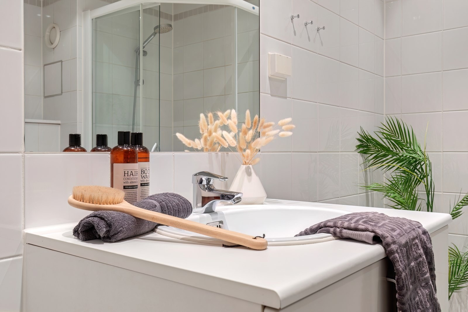 Badet er innredet med servant i baderomsmøbel, vegghengt toalett og dusjhjørne. Galleribilde