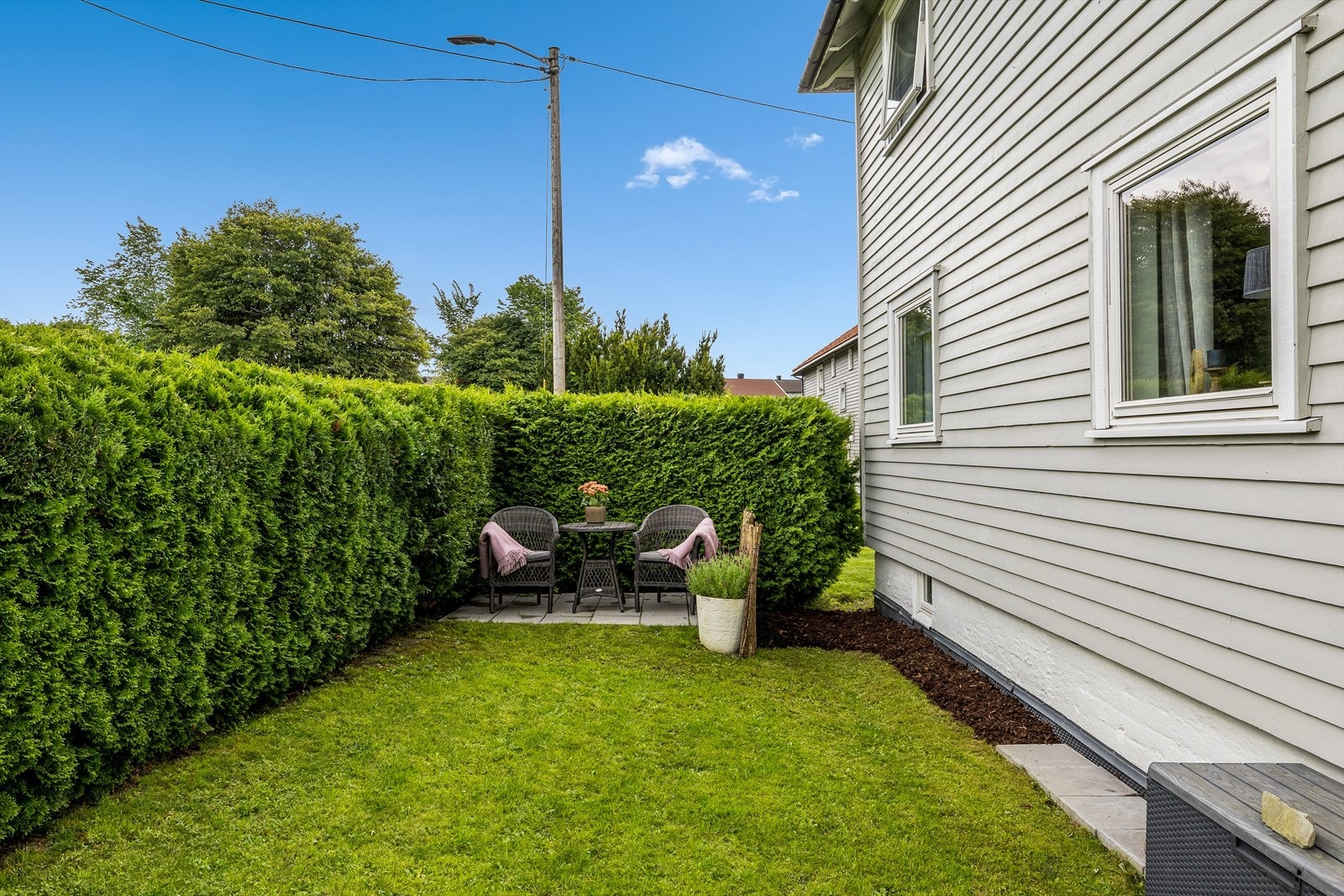 Med solen som skinner ned på uteplassen, vil du kunne nyte varme solstråler og en atmosfære av velvære. Galleribilde