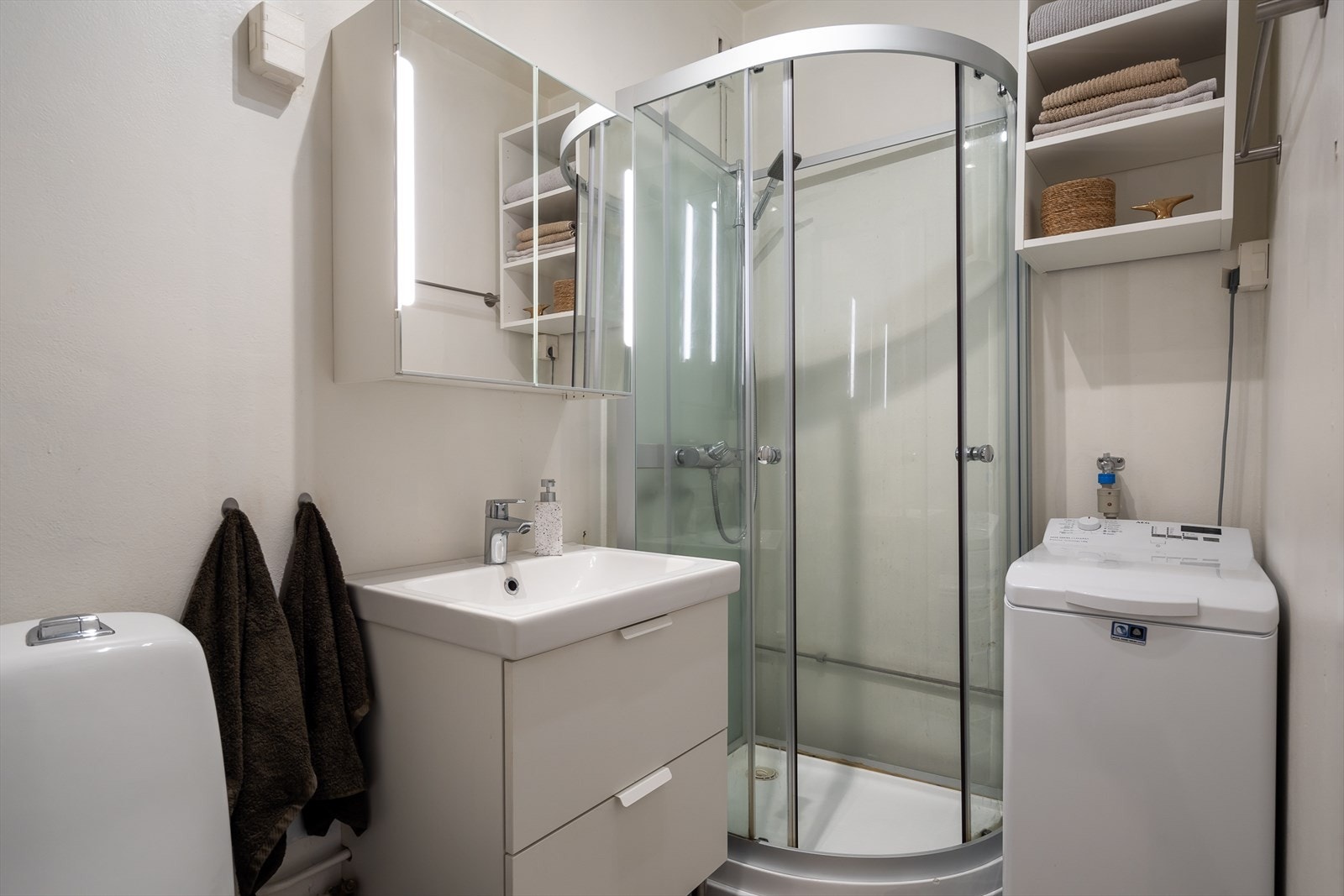 Baderommet innehar klosett, dusjkabinett og servant med skuffer og speilskap med lysarmatur over. Baderommet er eldre har derfor fått en tg3. Galleribilde