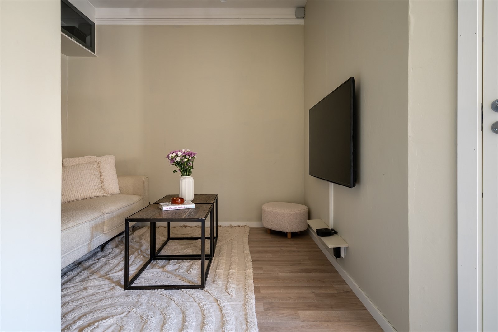 Over sofaen er det et plassbebygd skap med downlights under. Galleribilde