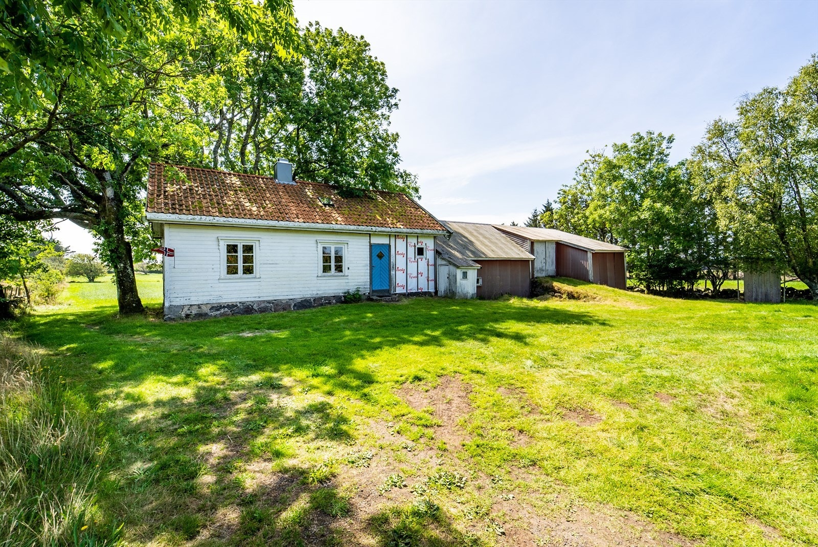 Flat tomt med plenlagte områder på baksiden av boligen med plass til parkering. Galleribilde