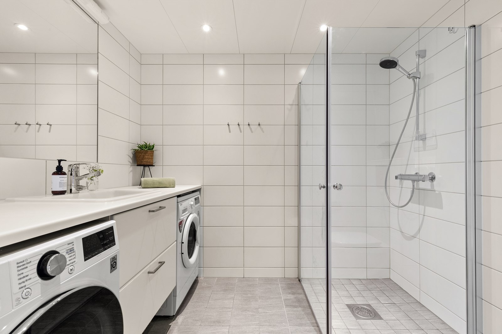 Innredningen består av servantskap med skuffeseksjon, speil, vegghengt toalett og dusjhjørne med svingdører. Galleribilde