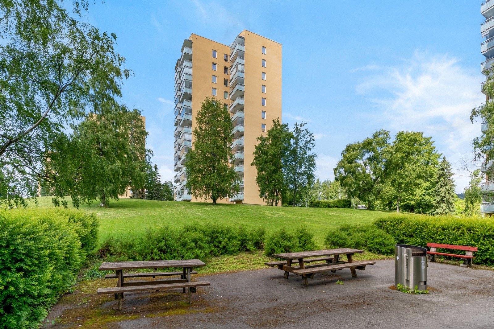 Tomten er pent opparbeidet med asfalterte internveier, grøntområder, beplantning og sittegrupper. Galleribilde