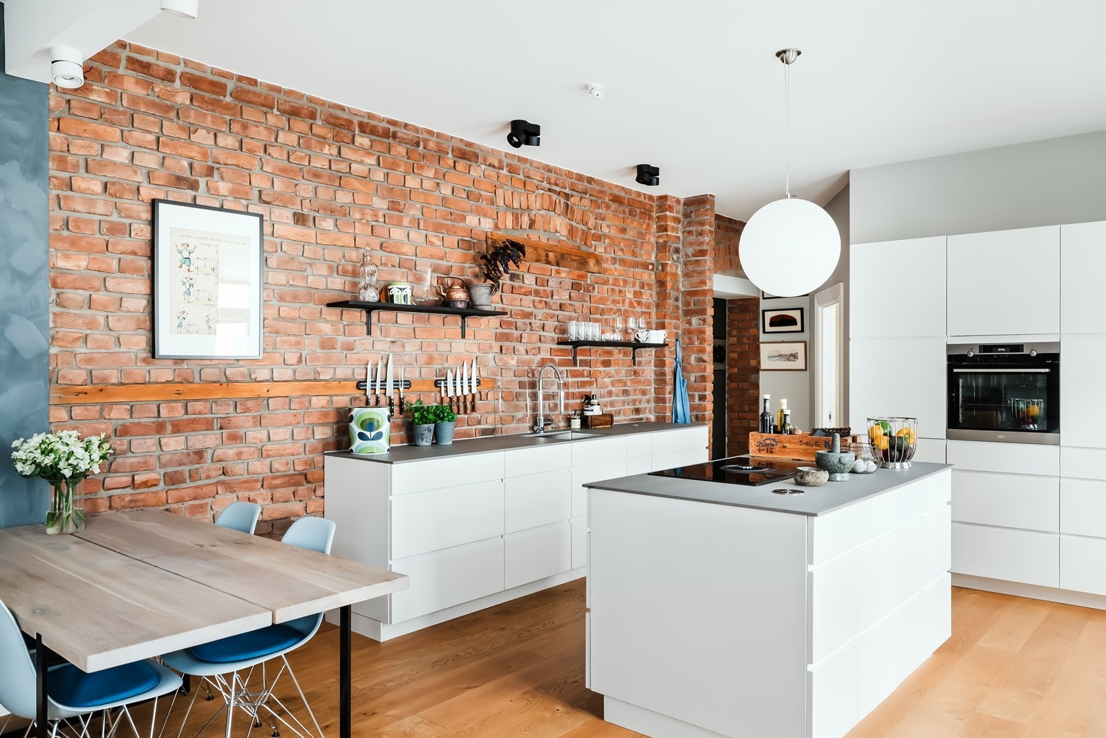 Stilrent, moderne og romslig Kvik-kjøkken fra 2018 med integrerte hvitevarer, flott kjøkkenøy og sjarmerende teglstensvegg Galleribilde
